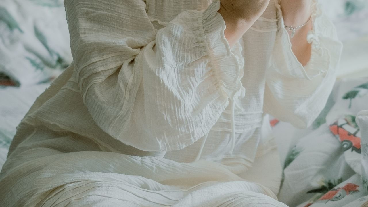mulher com camisola oversized de algodão off-white na cama